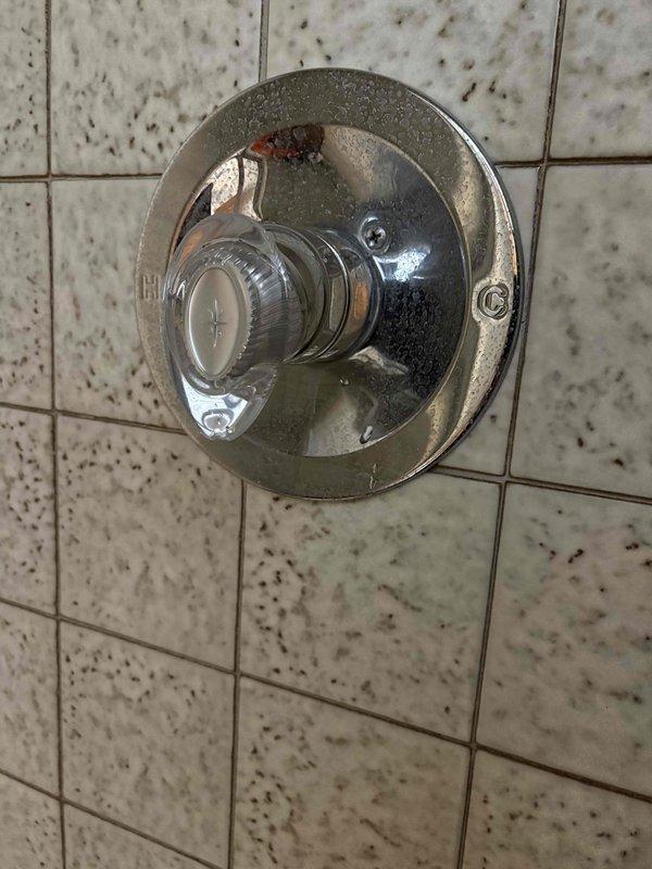 Responded to a service call for dripping shower head and faucet in second floor bathroom. Inspected P-trap assembly and plumbing under sink, noting mineral buildup and signs of wear. Serviced shower control valve, addressing mineral deposits on chrome fixture and resolving the persistent drip issue.