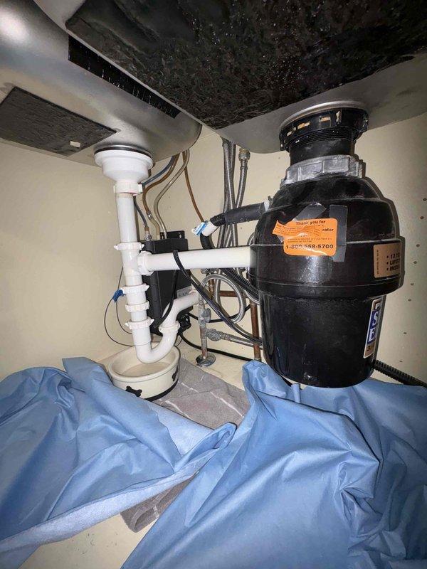 Responded to kitchen sink leak call. Upon inspection, identified water leakage from under-sink plumbing assembly. Serviced the P-trap connection and drain pipe assembly, ensuring proper sealing at all connection points. Checked garbage disposal unit connections for integrity. All components now functioning properly with no active leaks.