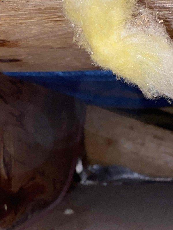 Responded to a water leak complaint affecting kitchen ceiling. Upon inspection of the crawl space above the kitchen, identified water damage and staining on wooden structural members. Located the source of the leak, repaired damaged section of plumbing, and secured surrounding insulation and vapor barrier to prevent future moisture issues.