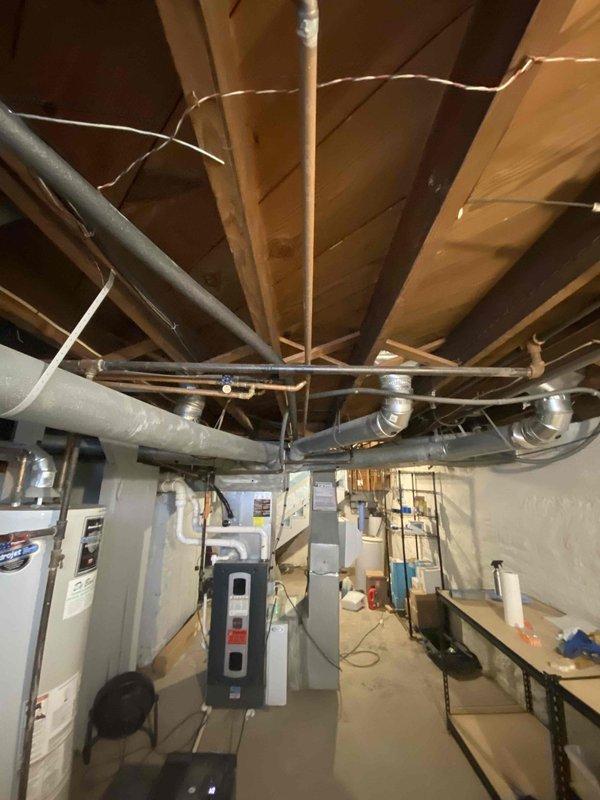 Conducted follow-up service call regarding persistent water leak at the base of recently glued pipe in the basement mechanical area. Inspected air handler installation and surrounding plumbing connections. Identified leak source at the connection point and resealed joint to prevent further moisture issues.