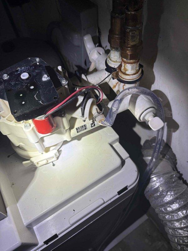 Diagnosed customer-installed 6-month-old Rheem water softener that was failing to automatically recharge. Identified faulty brine valve assembly with visible mineral buildup and corrosion at copper pipe connections. Repaired plumbing connection leak and restored proper water flow to enable automatic recharge cycle functionality.