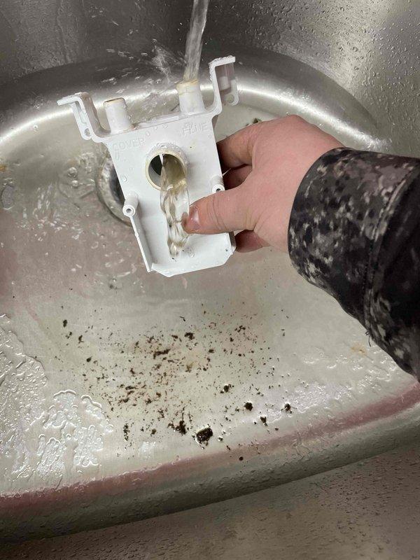 Responded to no heat complaint where customer reported indoor temperature at 66°F despite thermostat set to 73°F. Discovered clogged condensate drain in relatively new furnace system causing safety switch activation. Cleaned drain line components under running water to remove accumulated debris, restoring proper system operation and heat function.