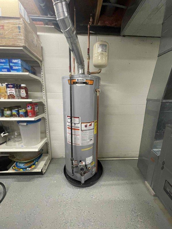 Successfully installed a new 50 gallon standard high recovery water heater (60,000 BTU) in basement utility area. System was properly connected to existing copper plumbing with expansion tank mounted on wall. Ventilation ducts were secured and all connections tested for proper operation as part of the service package that included complimentary Furnace + AC membership.