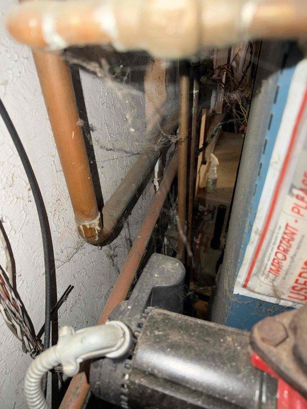 Inspected 30+ year old boiler system showing significant aging with rusted T-joint fittings and deteriorated components. Observed expansion tank with pressure gauge connection and examined copper piping network for potential repair needs. Documented system condition with photos to develop appropriate replacement/repair options as discussed with customer Bruno.
