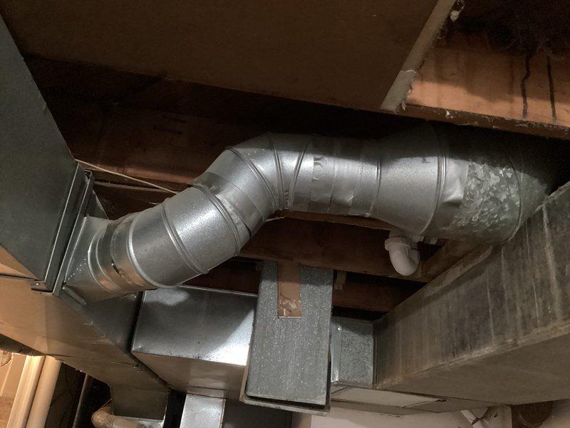 Performed initial assessment for potential HVAC system replacement at client's brother's residence. Inspected existing installation in basement, documenting current setup which includes galvanized ductwork with visible joints/seams and a rectangular air handler. System evaluation included examination of duct configuration, connections, and overall condition of the basement mechanical area where new equipment would be installed.