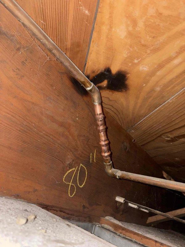 Identified and replaced corroded copper pipe joint showing significant mineral buildup and cracking that was causing a leak in the structural cavity. Documented damage to surrounding wood with visible water staining near the elbow connection. Consulted with Jason regarding the repair.