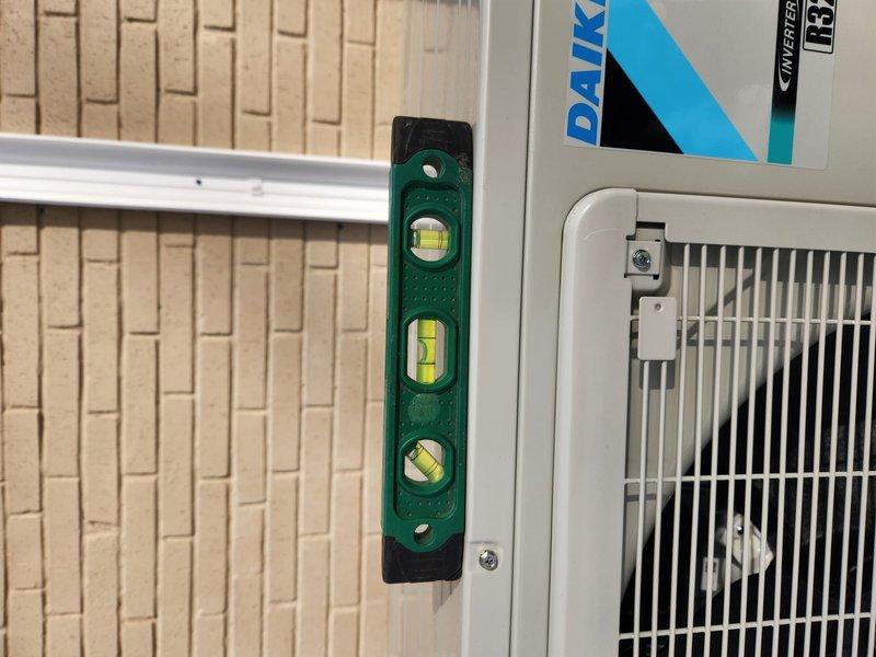 Completed installation of Daikin heat pump system (App ID 2603602512). Unit was properly leveled and secured to ensure optimal performance, with verification using spirit levels. Installed electrical junction box with appropriate cable entry points and mounted PVC line connections with proper support brackets.