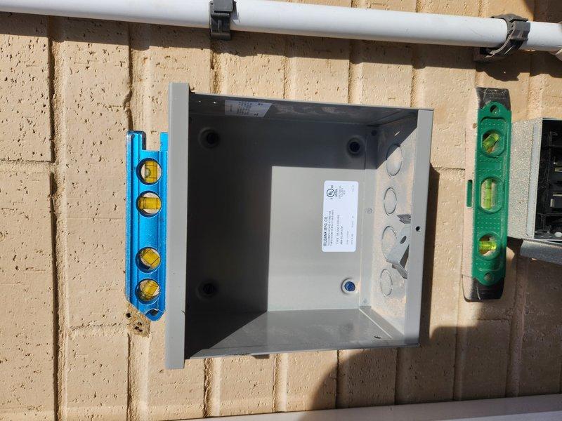 Completed installation of Daikin heat pump system (App ID 2603602512). Unit was properly leveled and secured to ensure optimal performance, with verification using spirit levels. Installed electrical junction box with appropriate cable entry points and mounted PVC line connections with proper support brackets.