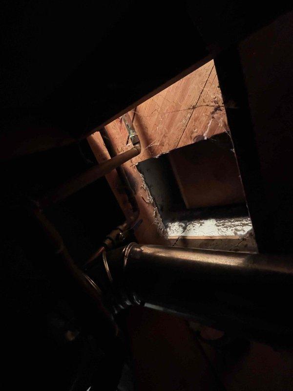 Assessed 22-year-old furnace with seizing blower motor that requires replacement. Inspected existing AC system and evaluated drain line configuration in utility area. Examined attic access point to determine proper installation path for new HVAC equipment.