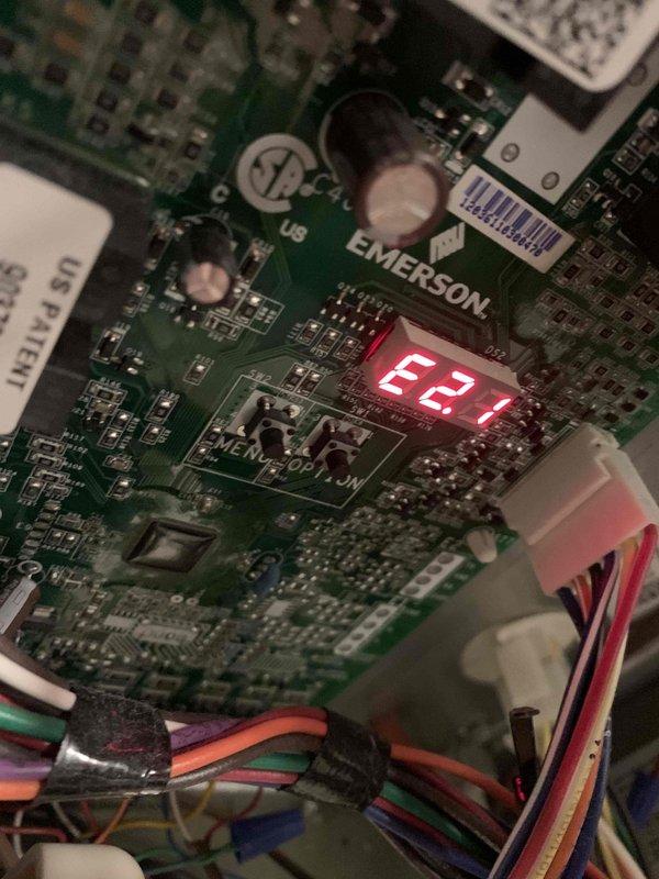 Diagnosed furnace issue for Ms. Bucco where unit was running but only producing cold air. Testing with Fieldpiece SC480 multimeter revealed voltage readings of 586.5V, and inspection of the EMERSON control board showed error code E2.1, indicating control board failure. Replaced defective control board to restore proper heating function.
