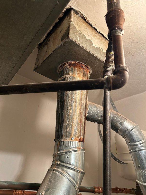 Conducted inspection of exhaust system to prepare quote. Identified significant corrosion on copper piping and assessed condition of galvanized metal ductwork connections in ceiling/wall penetrations. Documented existing ventilation infrastructure including support structures and potential moisture issues for comprehensive exhaust work proposal.