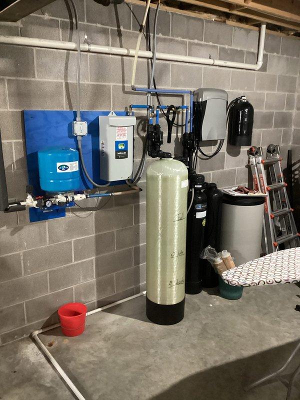Performed scheduled maintenance on tankless water heater system, completing comprehensive flush procedure to remove mineral buildup and scale. Inspected related water treatment components including pressure tank and filtration system. System operating normally with pump controller showing proper pressure readings post-service.
