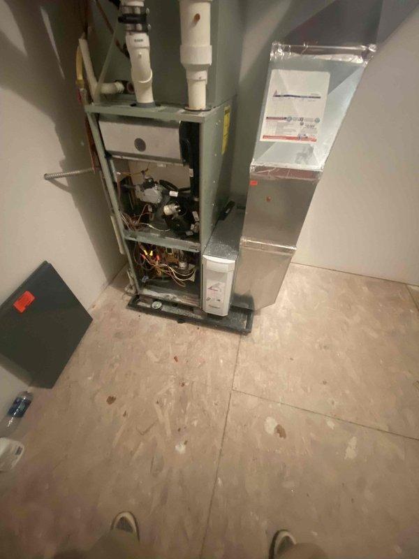 Technicians Matt H. and Homer flipped the air handler after finding a frozen wall affecting the HVAC system. Diagnostic work was partially completed, with Matt scheduled to return for further assessment once the wall has fully thawed. Interior inspection revealed exposed furnace components requiring attention.