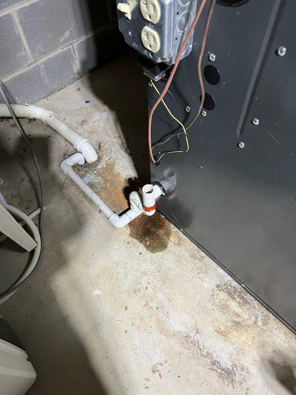 Responded to call back regarding water leakage at the furnace drain line. Identified improper sealing at PVC pipe joint with excessive application of pipe cement causing leakage onto concrete floor. Repaired connection with proper sealing technique and verified no further leakage at the air handler condensate drain.