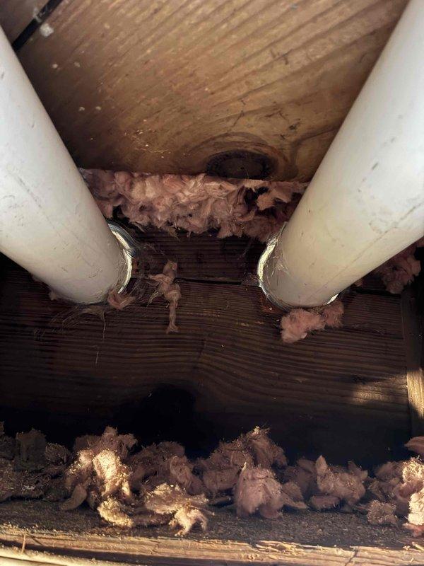 Completed installation of ductwork in basement utility area, routing insulated metal ducts through floor joists and connecting to existing HVAC system. Installed proper pipe penetrations through wooden structural members with fiberglass insulation for thermal efficiency. Coordinated with JondzEvan regarding chimney venting components to complete the installation.