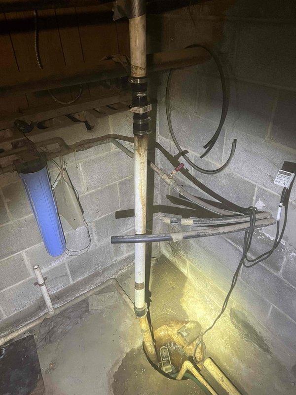 Responded to basement flooding call for HVAC technician Jeff. Diagnosed water intrusion issue originating from exterior drainage pipe containing standing water. Inspected basement utility area including sump pump system, water filtration components, and associated plumbing. Cleared snow from outdoor drainage access point to evaluate blockage contributing to basement water accumulation.