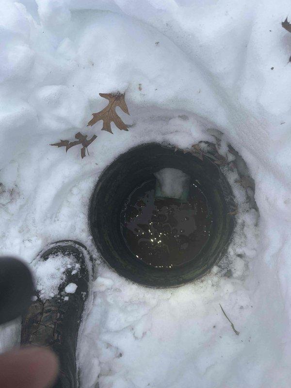 Responded to basement flooding call for HVAC technician Jeff. Diagnosed water intrusion issue originating from exterior drainage pipe containing standing water. Inspected basement utility area including sump pump system, water filtration components, and associated plumbing. Cleared snow from outdoor drainage access point to evaluate blockage contributing to basement water accumulation.