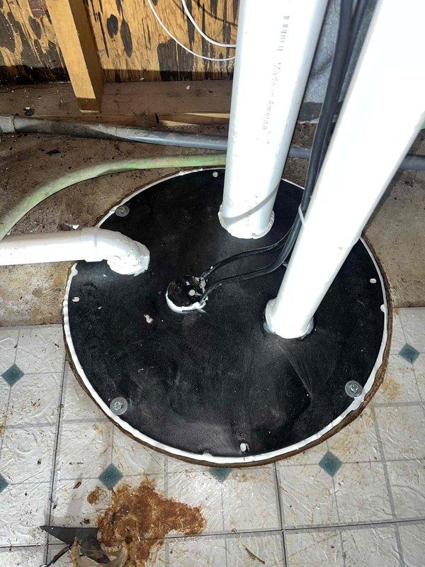 Returned to complete installation of previously sold grinder pump system with check valve and crock lid. Installed ABS and PVC piping with shut-off valve in basement utility area. Installation included securing base plate to floor and connecting discharge piping. Materials on order; work scheduled for completion upon delivery.