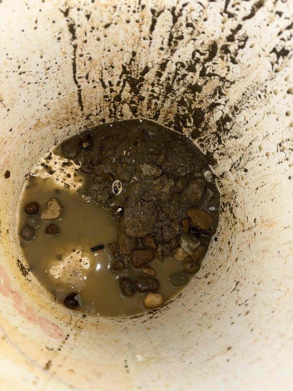 Responded to service call for sump pump failure that caused basement flooding. Upon inspection, found significant sediment and debris accumulation in sump pit, including rocks and pebbles that likely contributed to pump malfunction. Pump had automatically reactivated but required cleaning and testing to ensure proper operation.