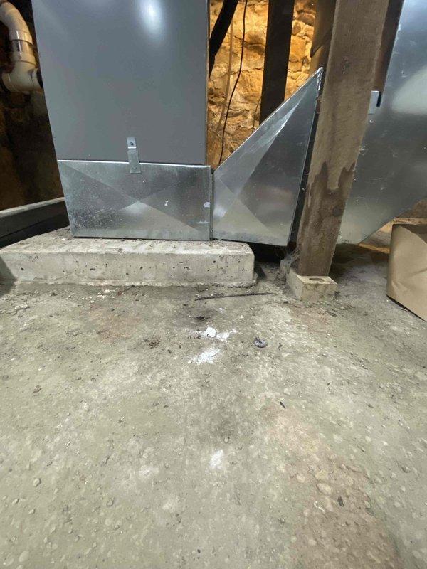 Assessed non-operational HVAC system in unfinished basement area. Customer currently has a heat pump system but expressed desire to convert back to gas heating. Inspection revealed existing ductwork with metal reinforcements and an air handler unit mounted near concrete foundation. Documented condition of equipment, electrical connections, and surrounding utility infrastructure for replacement proposal.