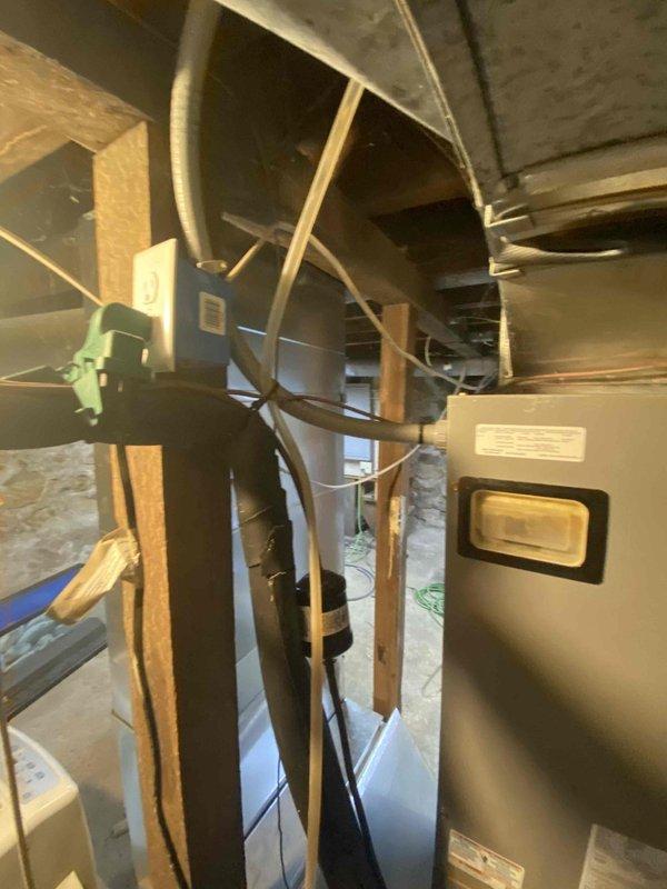 Assessed non-operational HVAC system in unfinished basement area. Customer currently has a heat pump system but expressed desire to convert back to gas heating. Inspection revealed existing ductwork with metal reinforcements and an air handler unit mounted near concrete foundation. Documented condition of equipment, electrical connections, and surrounding utility infrastructure for replacement proposal.