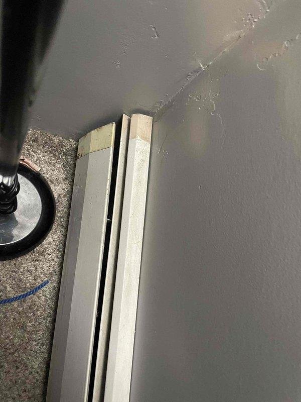 Inspected baseboard heating system for reported metal component issues. Observed water damage on adjacent wall with visible stains and cracks. Applied protective tape at corner junctions of baseboard units in preparation for necessary repairs to restore proper heating function.