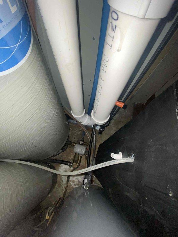 Assessed furnace installation in non-riser configuration requiring removal for ductwork access. Existing HVAC system includes water filtration components and a white rectangular air handler unit mounted against wall with black insulated ductwork above. Coordination with ductwork team required for proper sequencing of removal and reinstallation.