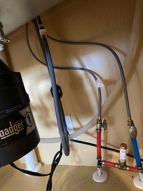 Performed complete replacement of kitchen garbage disposal unit, installing new "Pager 1" model with proper electrical and plumbing connections. Additionally, replaced toilet tank internal components including flush valve assembly and fill valve mechanism with new parts featuring red caps. Both installations were completed with verification of proper function and no leaks.