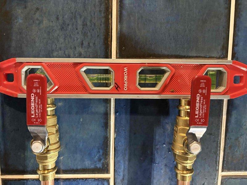 Responded to service call for leaking SharkBite fitting on custom shower head that was originally installed in 2022. Inspected the MANABLOC plumbing manifold system and verified proper alignment of the brass LEGEND shut-off valves using a WORKPRO level. Successfully repaired the leaking connection, restoring proper function to the shower fixture.