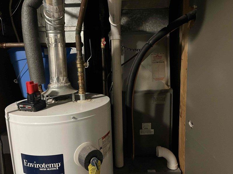 Responded to follow-up service call for reported loud blower motor in air handler. Accessed unit through narrow passageway between residential structures during winter conditions. Inspected water heating system and adjacent HVAC equipment in utility area, identifying and resolving noise issue with the blower assembly.