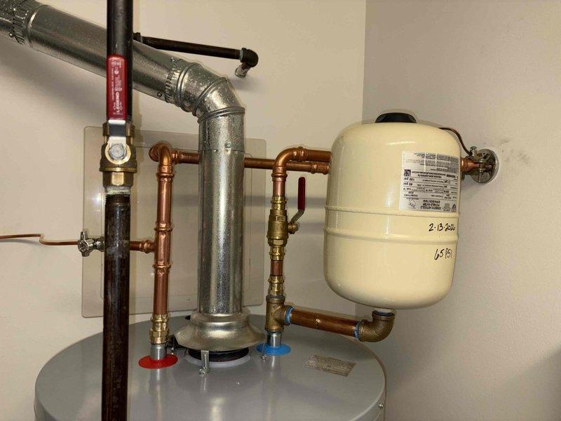 Successfully installed new tanked water heater as per previous sale agreement. Verified proper pressure readings of approximately 50-60 PSI on the Woodford valve assembly. Installed expansion tank with appropriate copper and galvanized pipe connections, ensuring all fittings were secure and operational with no leaks detected.