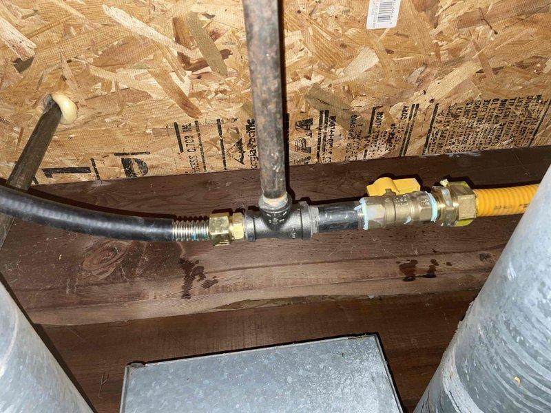Completed gas piping installation with brass valve and flexible gas line connection in wall cavity. Installation included securing line with appropriate bracketing and connecting to existing metal piping system. Coordinated work with roofing contractor as per service agreement.