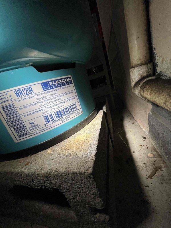 Responded to callback regarding knocking noise in shower after previous service. Inspected plumbing system and discovered expansion tank (Flexcon WR120R) needed adjustment. Secured loose pipe brackets in wall cavity that were causing water hammer effect during temperature changes. Problem resolved with no further remediation needed.