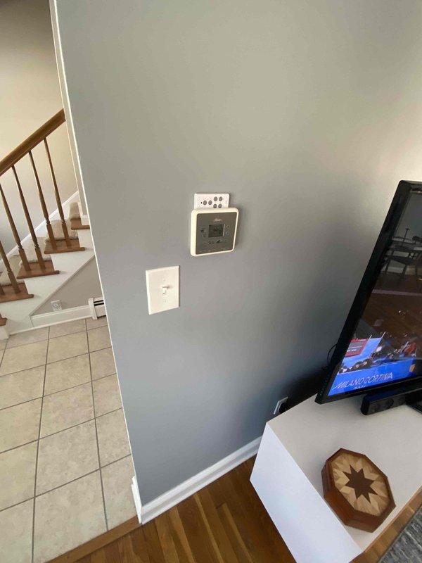 Conducted boiler system evaluation for a two-story home with heating imbalance issues - upstairs cold while first floor maintains adequate heating. Inspected existing hydronic heating system in basement mechanical room, including blue boiler unit, copper piping network, and associated controls. Documented current thermostat configuration and temperature differentials between floors to determine appropriate solution for balanced heating distribution.