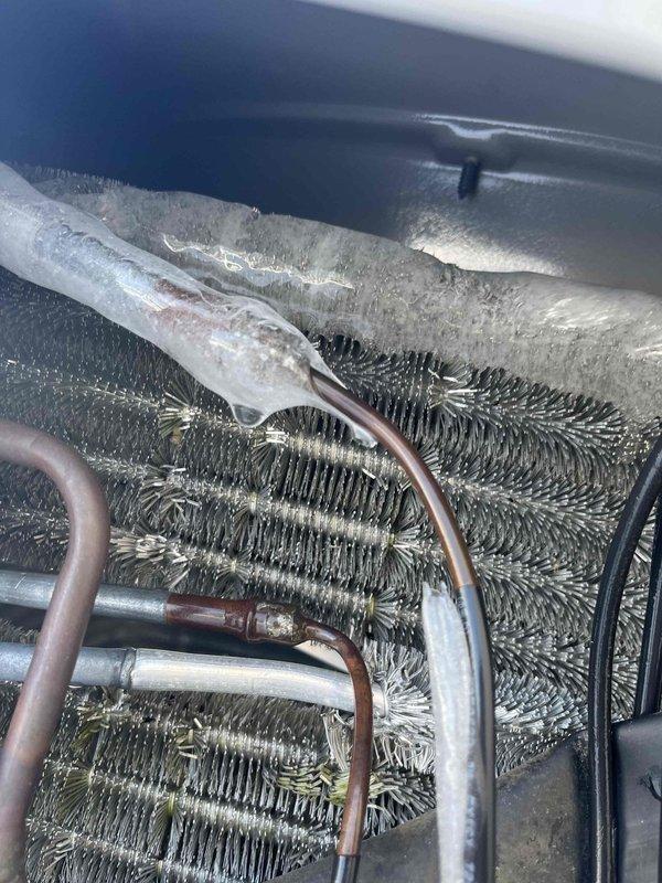 Performed warranty service on heat pump system. Diagnosed evaporator coil with significant frost buildup and ice formation on refrigerant lines. Corrected refrigerant charge and cleaned coil surfaces to restore proper heat exchange functionality and system operation.