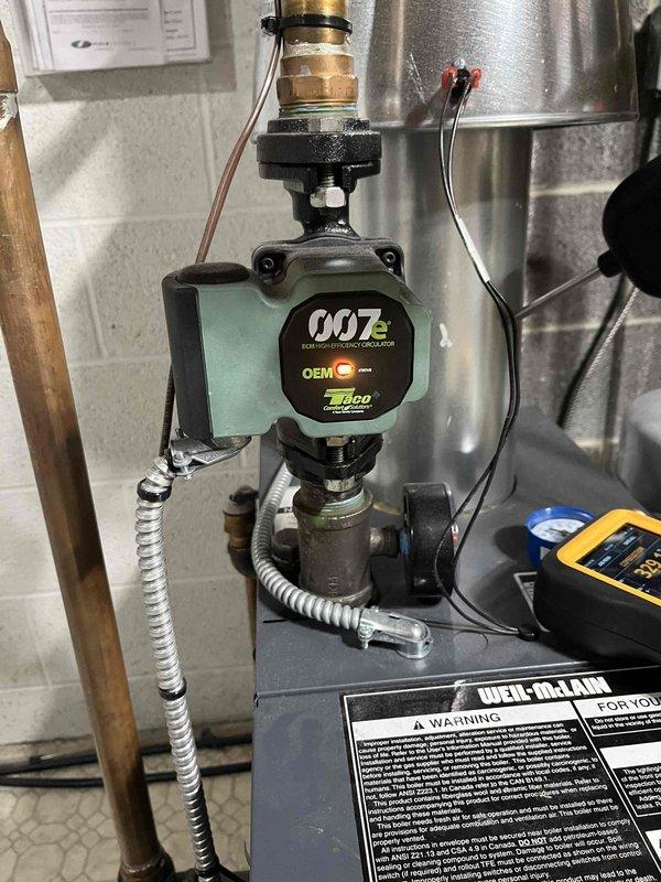 Completed boiler maintenance visit for club member. Inspected Taco NXT ECM high-efficiency circulator pump installation and connections. Verified system pressure at 25 PSI on Brady gauge, confirming proper operation within normal parameters.