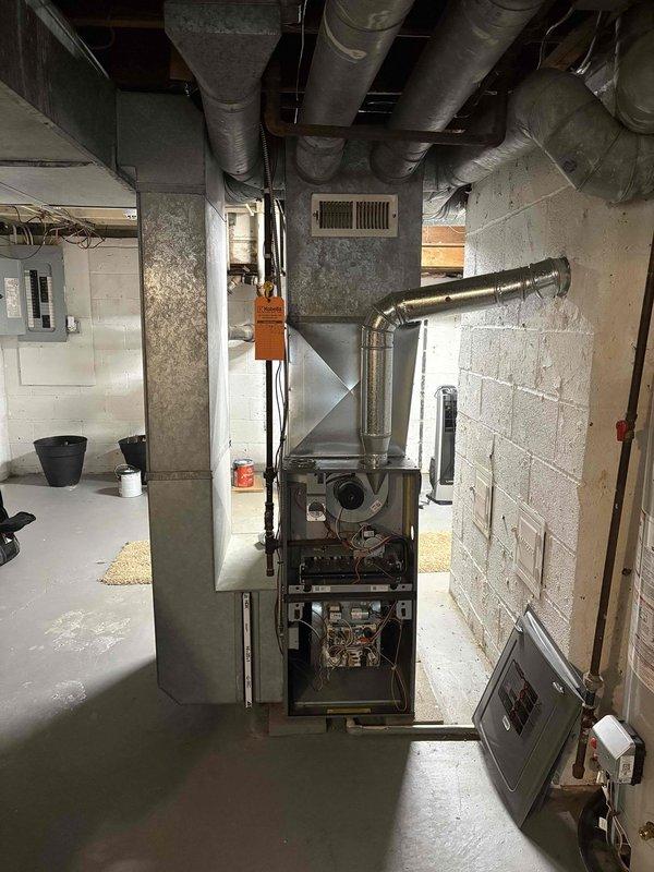 Conducted site evaluation for mini split installation in addition room. Inspected existing HVAC system, including furnace with exposed internal components and associated ductwork in utility area. Examined exterior wall mounting options and current electrical connections to determine optimal placement for new mini split system.