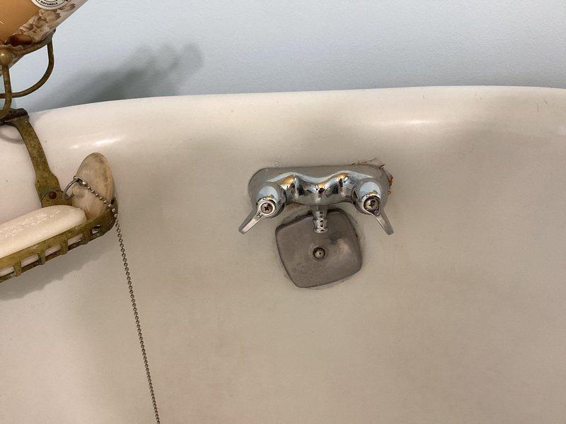 Inspected clawfoot bathtub faucet with shower handle and provided replacement estimate as requested. Examined bathroom sink that is detaching from wall and documented current condition. Photos taken of both the decorative bathroom sink with ornate soap dispenser and the aging chrome bathtub faucet with visible wear to support assessment and estimate.