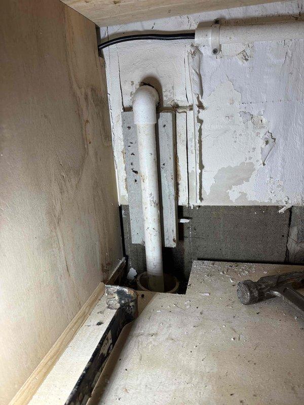 Performed follow-up service visit regarding previously reported drain line issue. Upon inspection, identified deteriorated wall section surrounding PVC drain pipe with visible water damage and peeling paint. Cleaned affected area and confirmed proper drainage function to prevent future moisture accumulation.