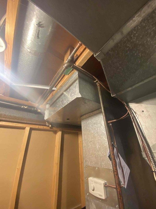 Conducted comprehensive assessment of 20-year-old furnace and same-age AC system, both currently operational. Inspected existing ductwork configuration and connections in utility space, noting metal ductwork condition and copper line placement. Evaluated basement mechanical room housing current furnace unit, water heater, and associated distribution systems for replacement feasibility.