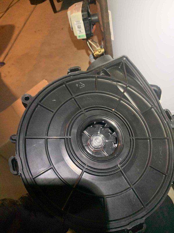 Completed warranty service on HVAC system, replacing a defective blower motor assembly. Removed the old black plastic wheel housing unit with damaged hub, installed new motor with proper electrical connections, and verified proper operation of the system after installation.