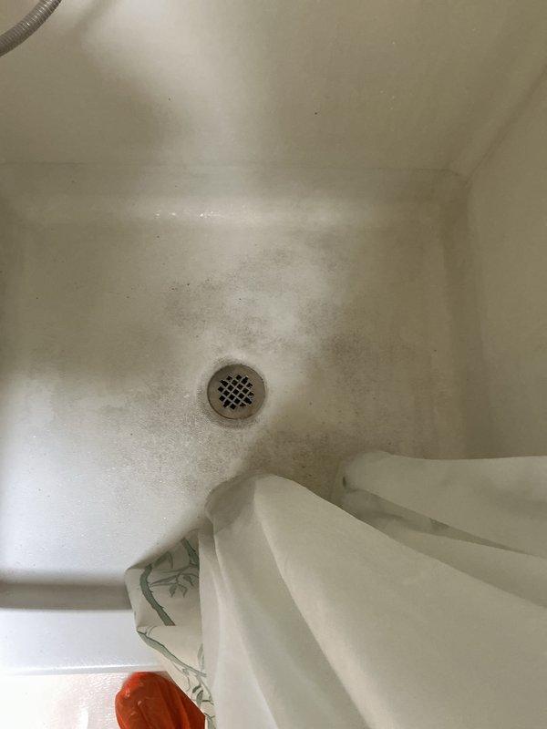 Conducted routine plumbing membership visit as requested to inspect outdoor faucet. Examined shower basin showing significant dark staining/mildew accumulation around drain area. Inspected water heater installation with copper supply lines and functioning shut-off valves with red handles; all connections appear properly secured with no visible leaks.
