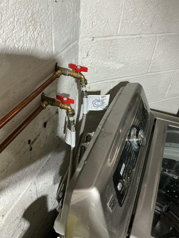Conducted routine plumbing membership visit as requested to inspect outdoor faucet. Examined shower basin showing significant dark staining/mildew accumulation around drain area. Inspected water heater installation with copper supply lines and functioning shut-off valves with red handles; all connections appear properly secured with no visible leaks.