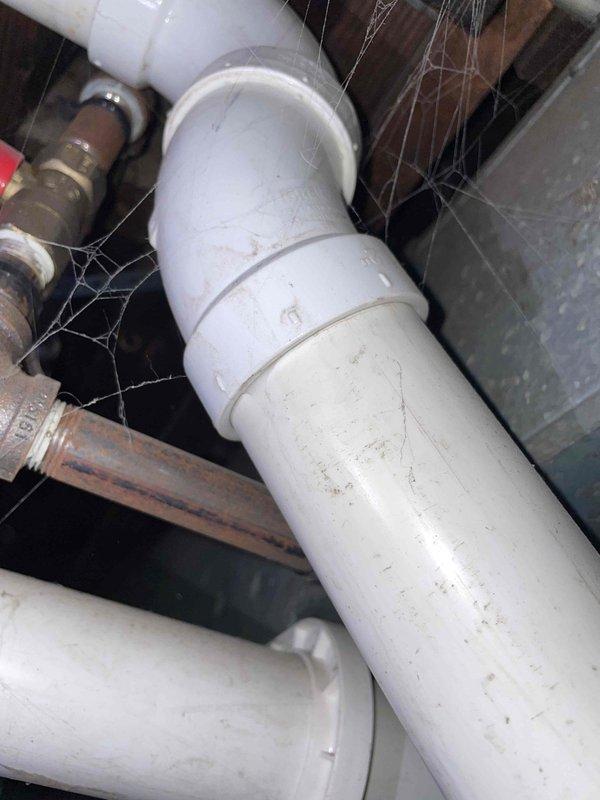 Responded to service call for non-functional furnace. Inspection of basement utility area revealed extensive cobweb buildup on plumbing infrastructure and signs of oxidation on metal fittings where copper/brass connects to PVC. System was thoroughly cleaned and restored to proper working condition.