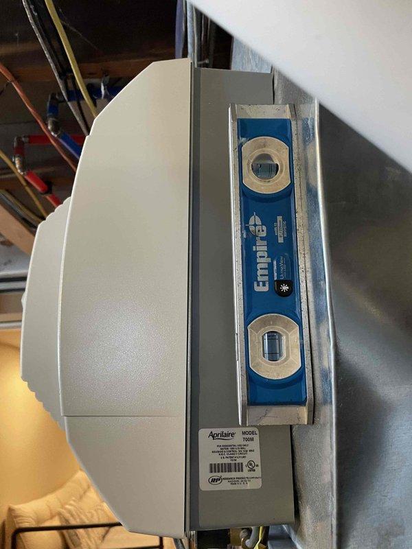 Performed diagnostic on furnace system due to reported heat loss and temperature inconsistency. Inspected Aprilaire whole-house humidifier installation, verifying proper mounting and level positioning. Examined electrical connections including multiple wire bundles (green, yellow, blue, red, white, and black) at terminal block, confirming secure fastening and appropriate routing within the system.