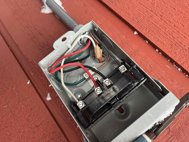 Performed warranty service call to inspect electrical disconnects mounted on exterior wall. Examined junction boxes showing deteriorated weatherproofing and potentially unsafe wiring connections. Replaced defective disconnects with new units, properly secured all electrical connections, and applied appropriate sealant to ensure weather-tight installation per manufacturer specifications.