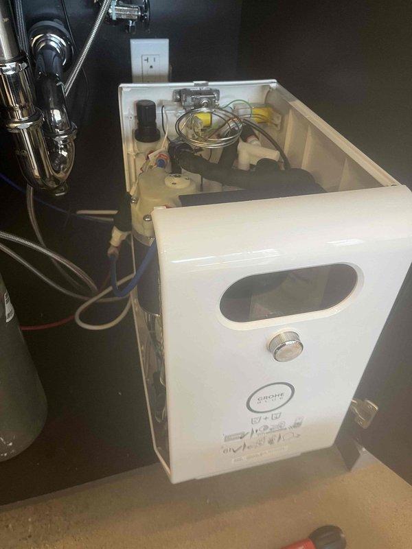 Responded to service call for commercial water treatment system showing error code with associated leak. Inspected quick-connect fittings on filtration unit where water line was leaking at connection point. Repaired compromised connection between blue/white tubing and plastic fittings, securing the system components and ensuring proper seal at the junction points.