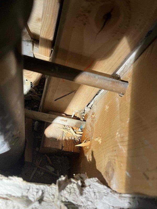 Responded to emergency water leak affecting ceiling below bathroom. Inspected structural framing where water damage was evident in wooden joists and surrounding materials. Repaired main shut-off valve which was identified as the source of the leak, preventing further water intrusion and structural damage.