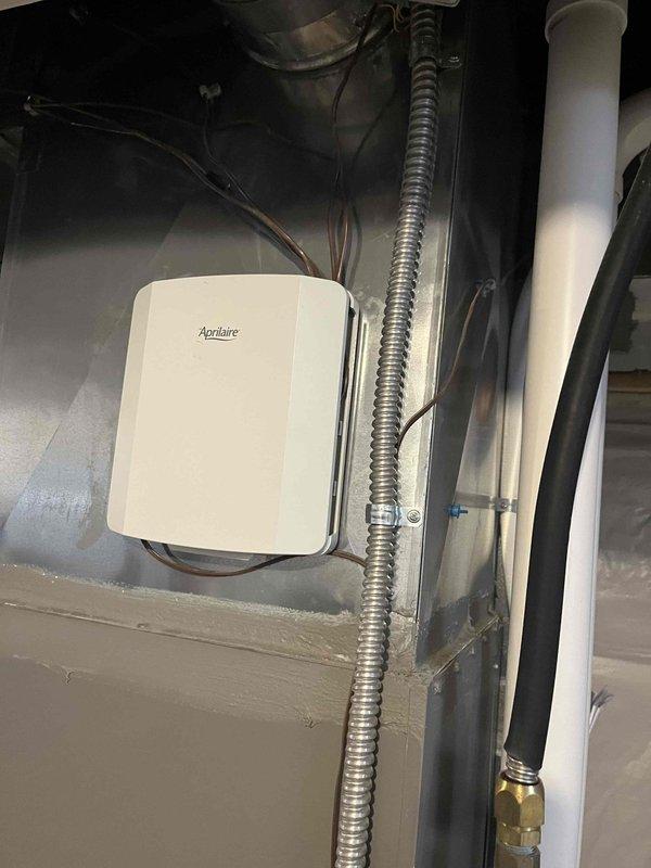 Responded to service call for whistling sound on first floor when second floor HVAC system operates. Inspected zone damper system and identified loose ductwork connections causing air leakage. Sealed joints with aluminum tape and verified proper operation of Aprilaire humidity control unit mounted on air handler.