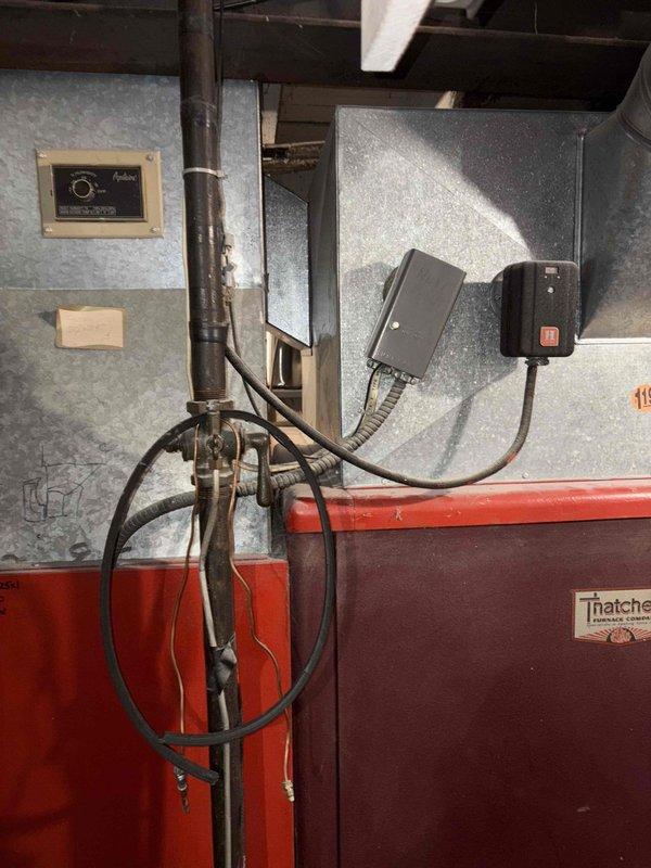 Inspected existing heating system, which consists of an aging Thatcher furnace with no current AC capabilities. Unit is operational but outdated. Customer expressed interest in adding air conditioning. Documented current installation configuration including control interfaces, piping connections, and mechanical room layout to prepare comprehensive replacement estimate for both heating system upgrade and new AC installation.
